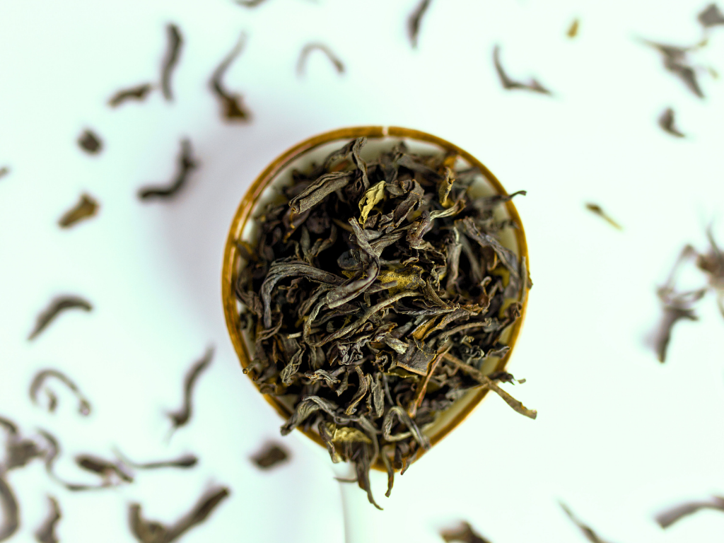 Mint Medley Black Tea's high quality loose leaf is seen in a spoon.