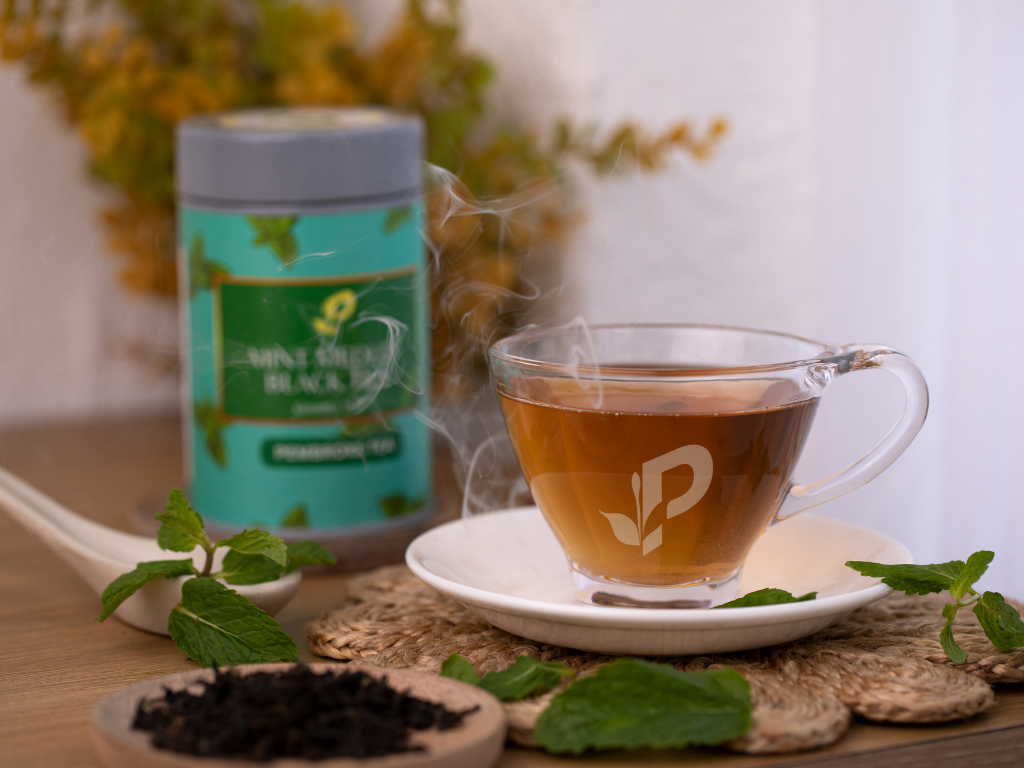 Mint Medley Black Tea loose leaf tin by Pembroke Tea with a teacup with tea in it. This image shows fresh soothing tea.